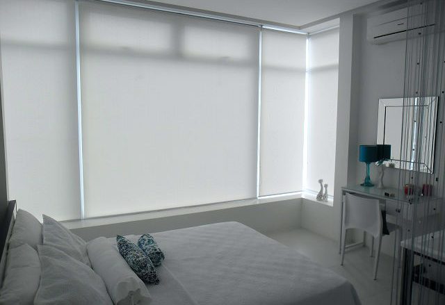 White Roller Blinds Installed in a Relaxing White Bedroom