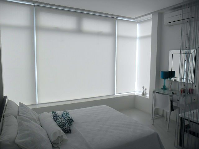 White Roller Blinds Installed in a Relaxing White Bedroom